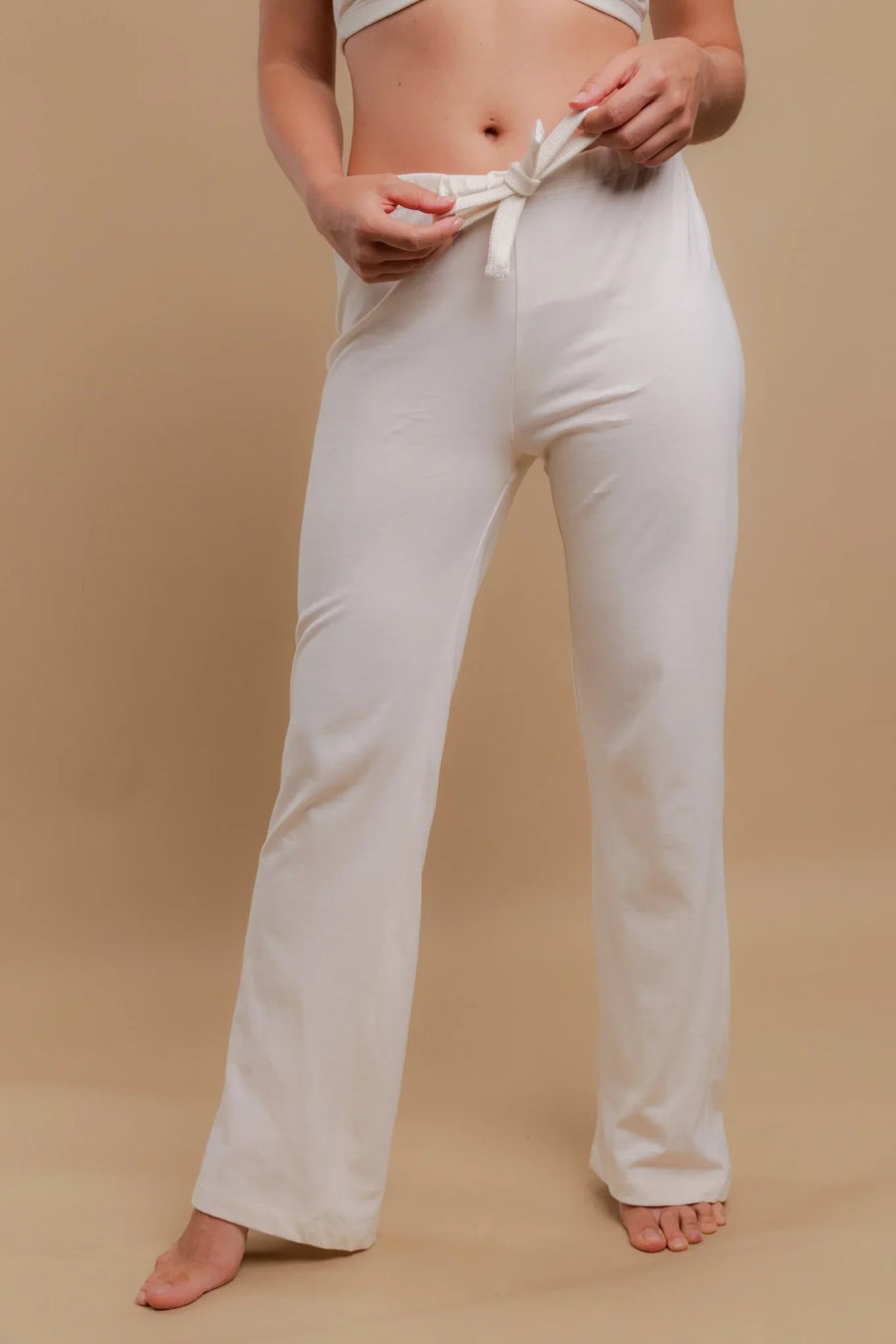 Woman wearing ivory organic cotton drawstring pajama pants for sensitive skin