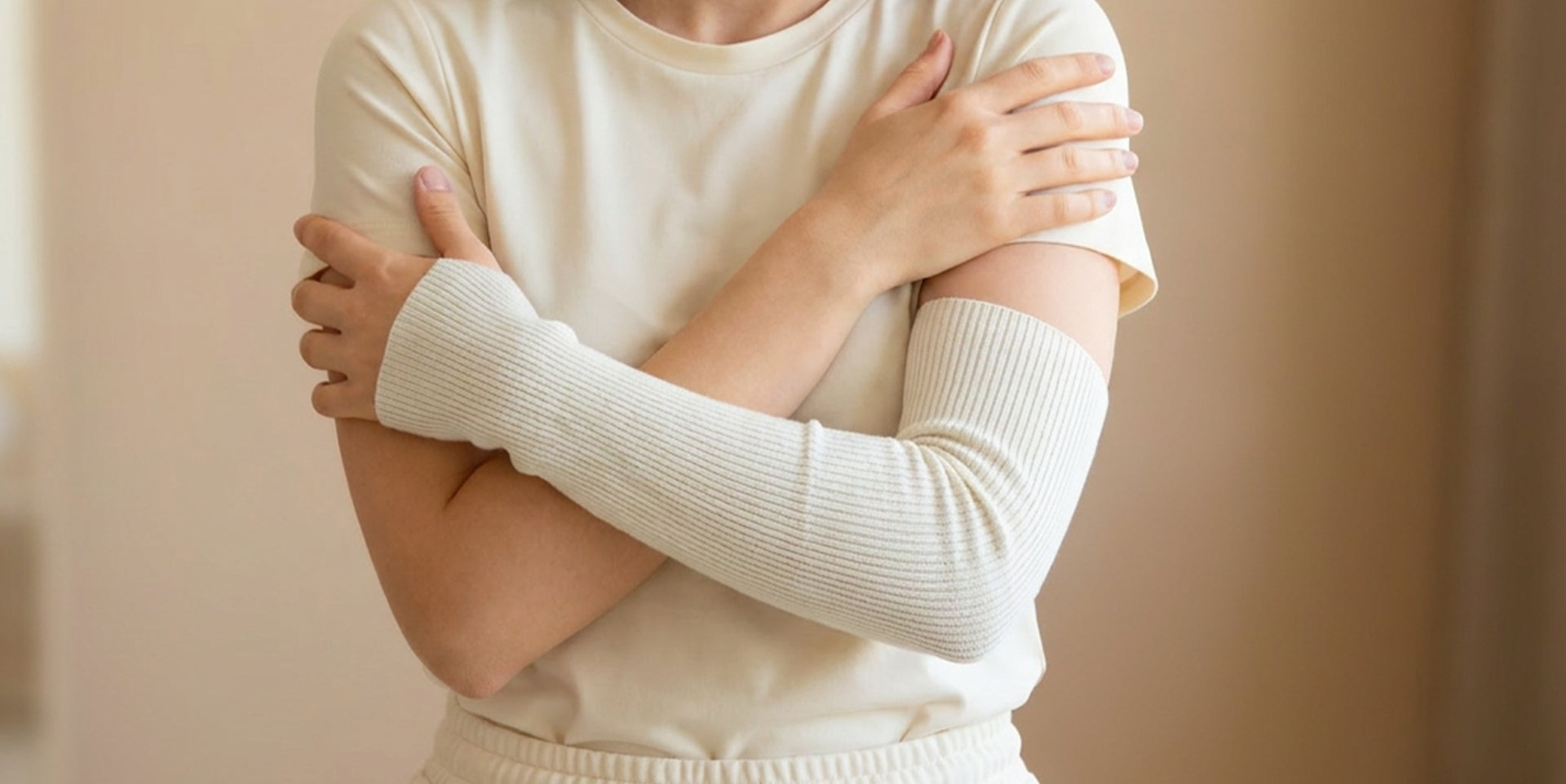 Person wearing a white cotton tubular bandage on their arm for skin support