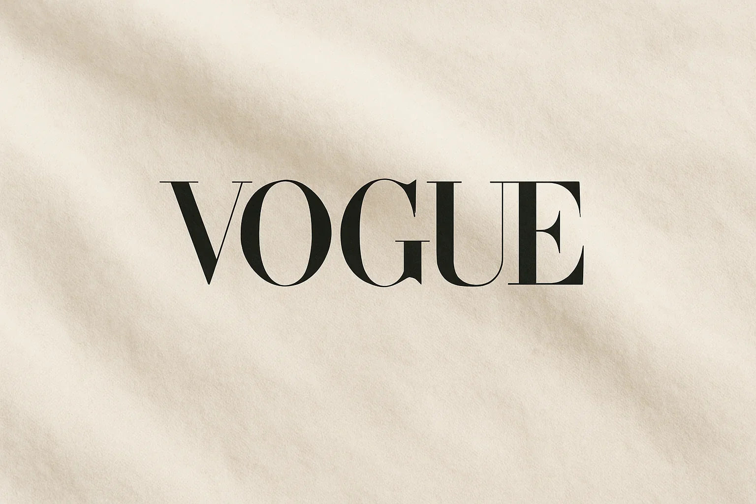 VOGUE text in bold black font on a soft, cream cotton fabric background