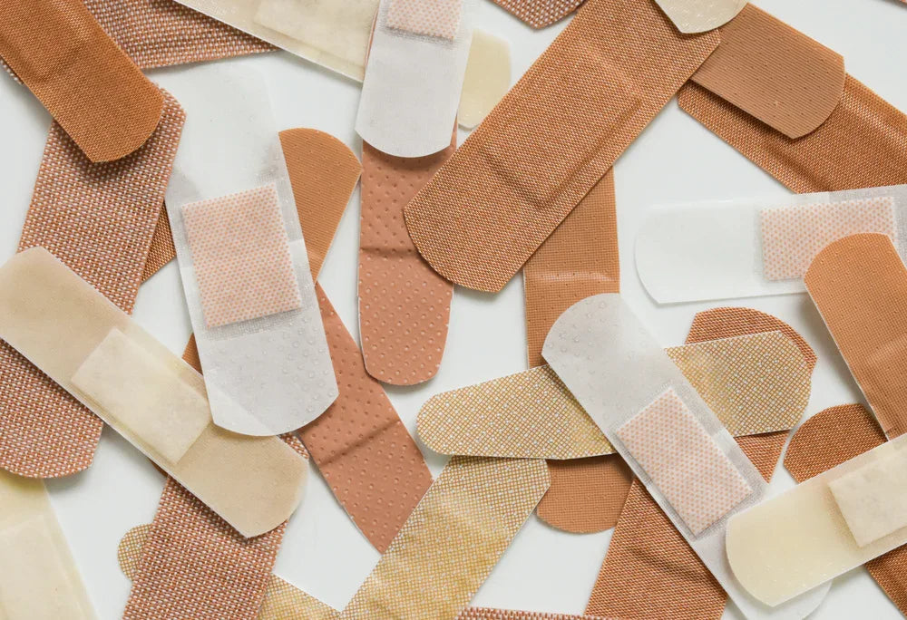 Assorted hypoallergenic adhesive bandages scattered on a white surface