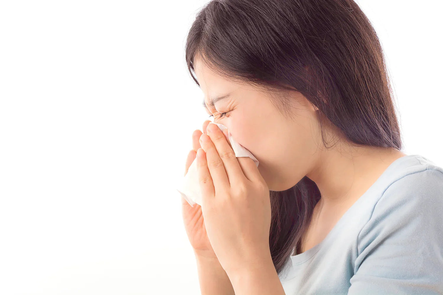 Woman sneezing into tissue, allergy relief, sensitive skin, white background