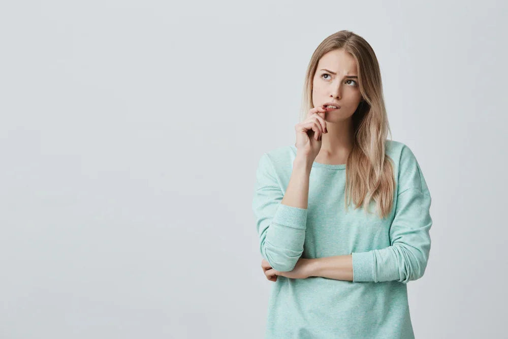 Woman in allergy-free cotton Mint sweater looking thoughtful, Cottonique hypoallergenic apparel