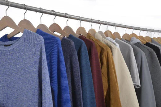 Assorted synthetic-blended shirts and sweaters on hangers, clothing rack display