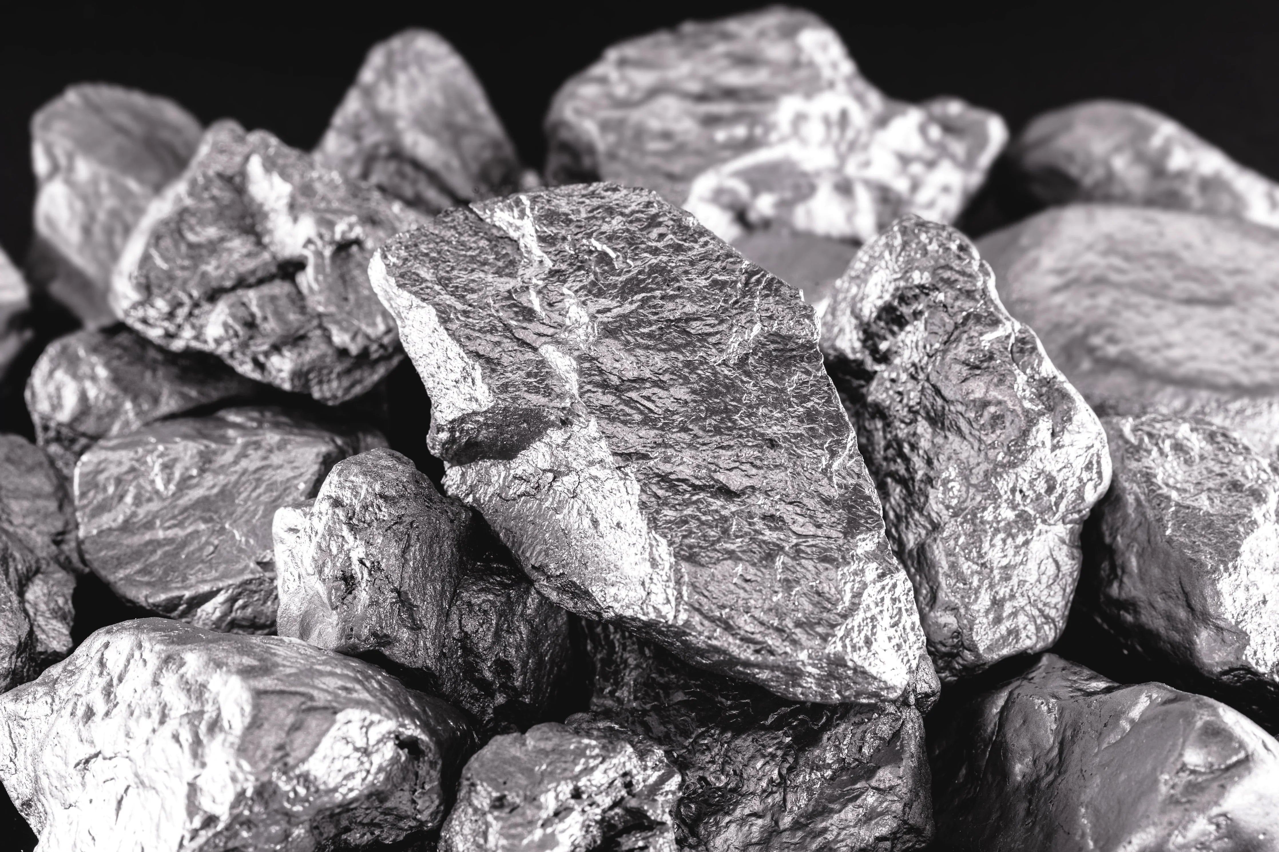Close-up of raw, metallic cobalt ore rocks with rough texture on a dark background