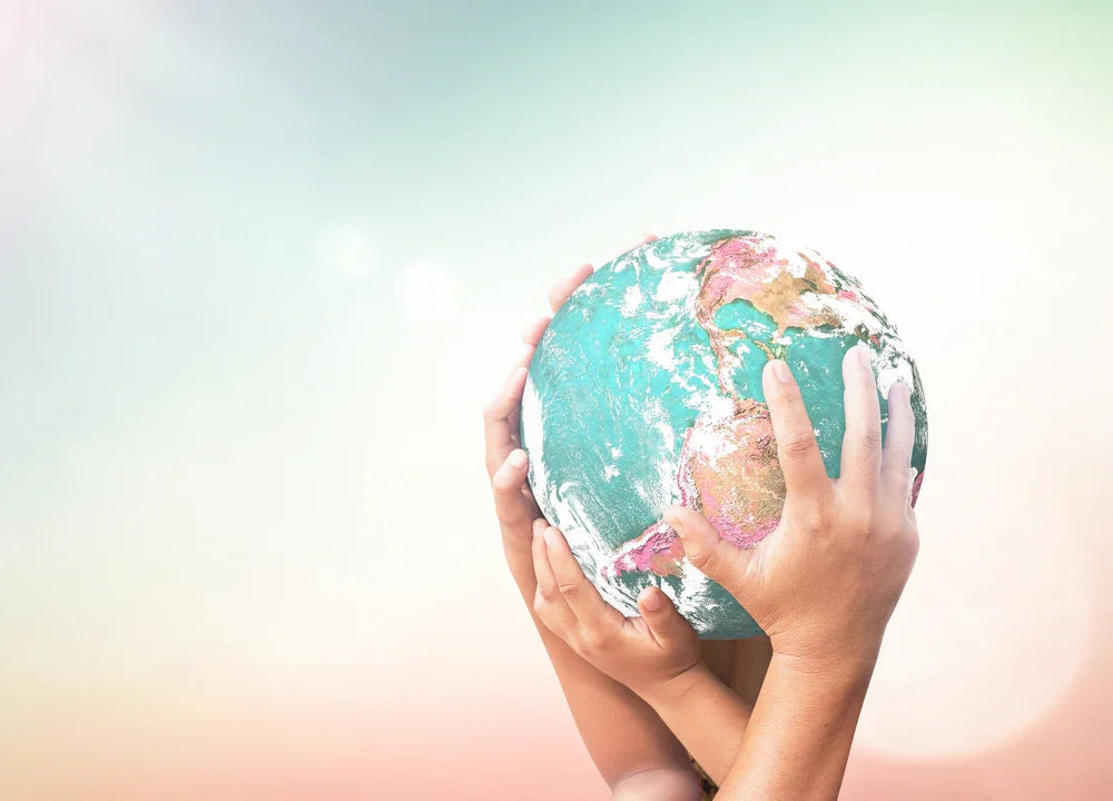 Diverse hands holding globe, symbolizing allergy-free, sustainable apparel by Cottonique