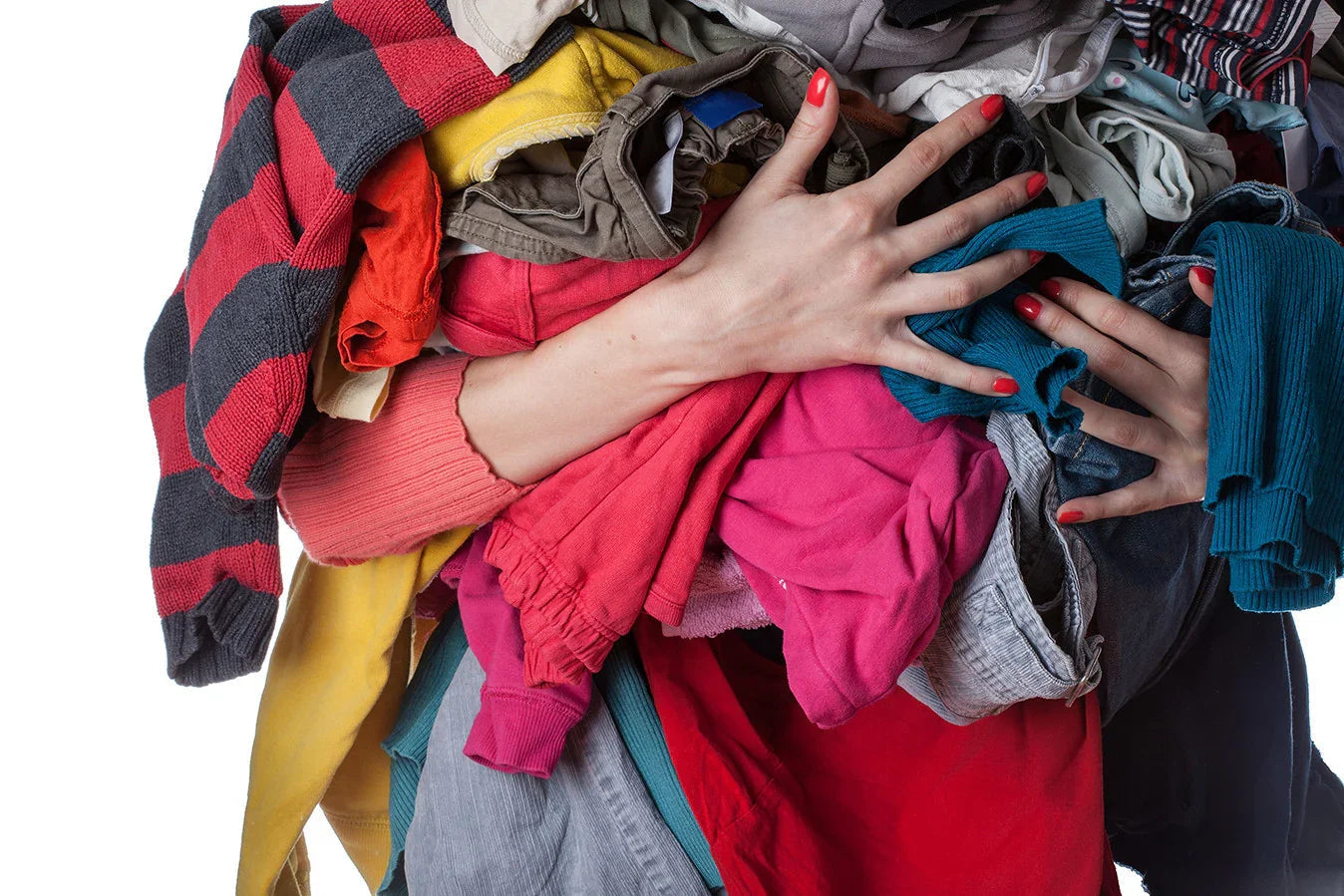 Person holding a large pile of colorful cotton clothing, suitable for sensitive skin