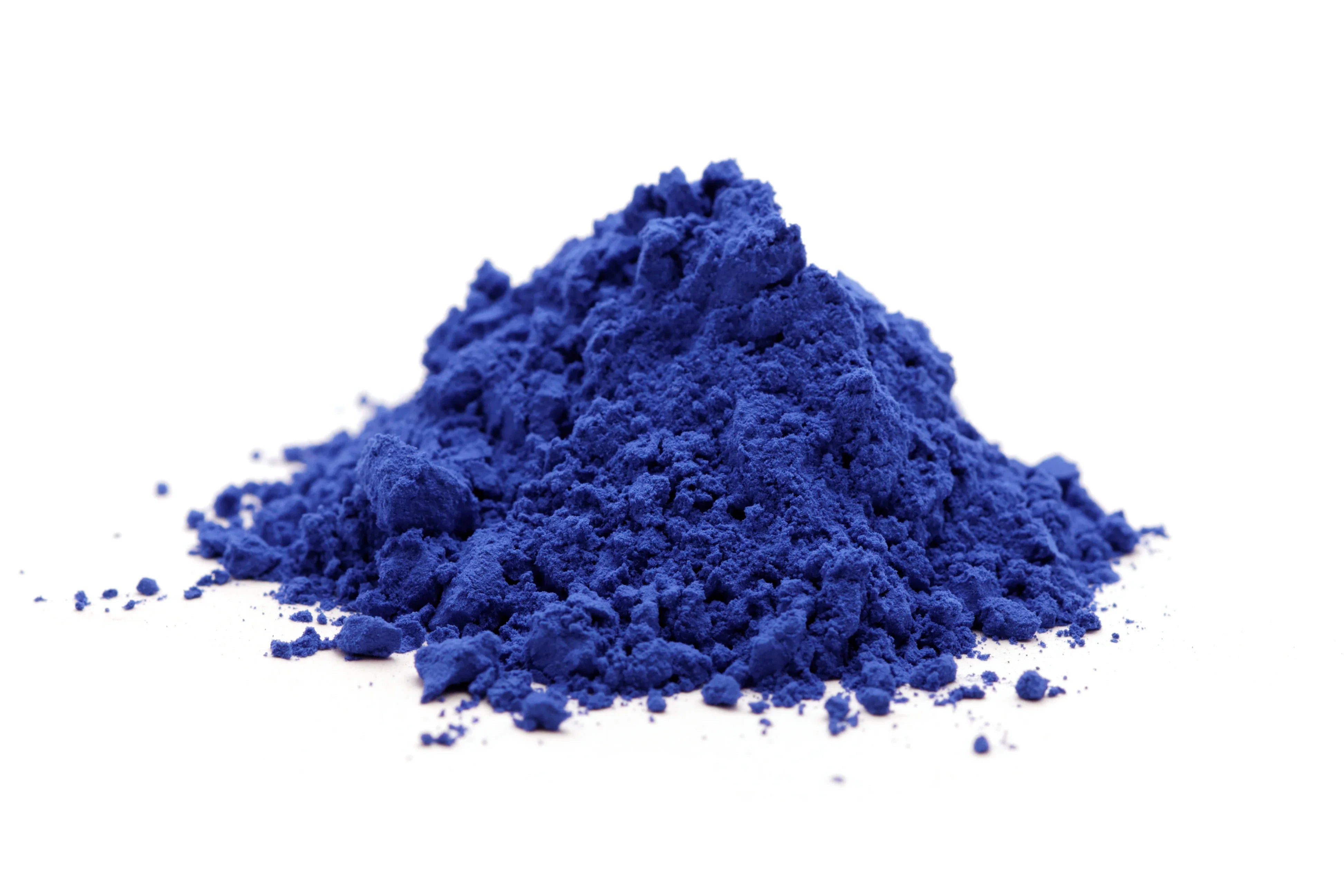 Pile of vibrant blue natural dye powder on white background