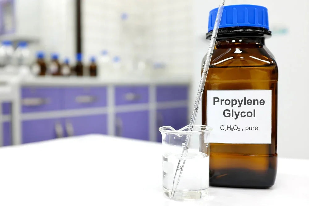 Brown bottle labeled Propylene Glycol and glass beaker with liquid in laboratory setting