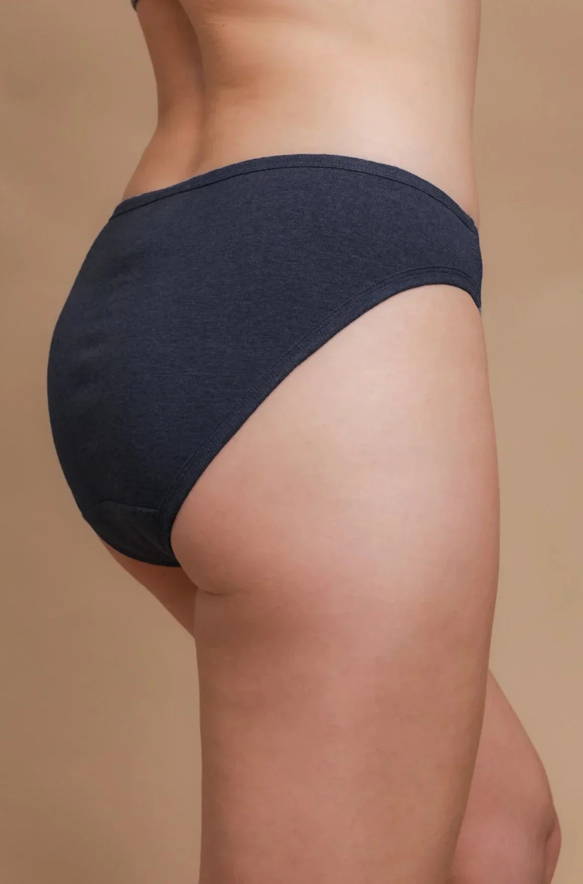 Hypoallergenic cotton underwear in dark blue by Cottonique, shown on model against beige background