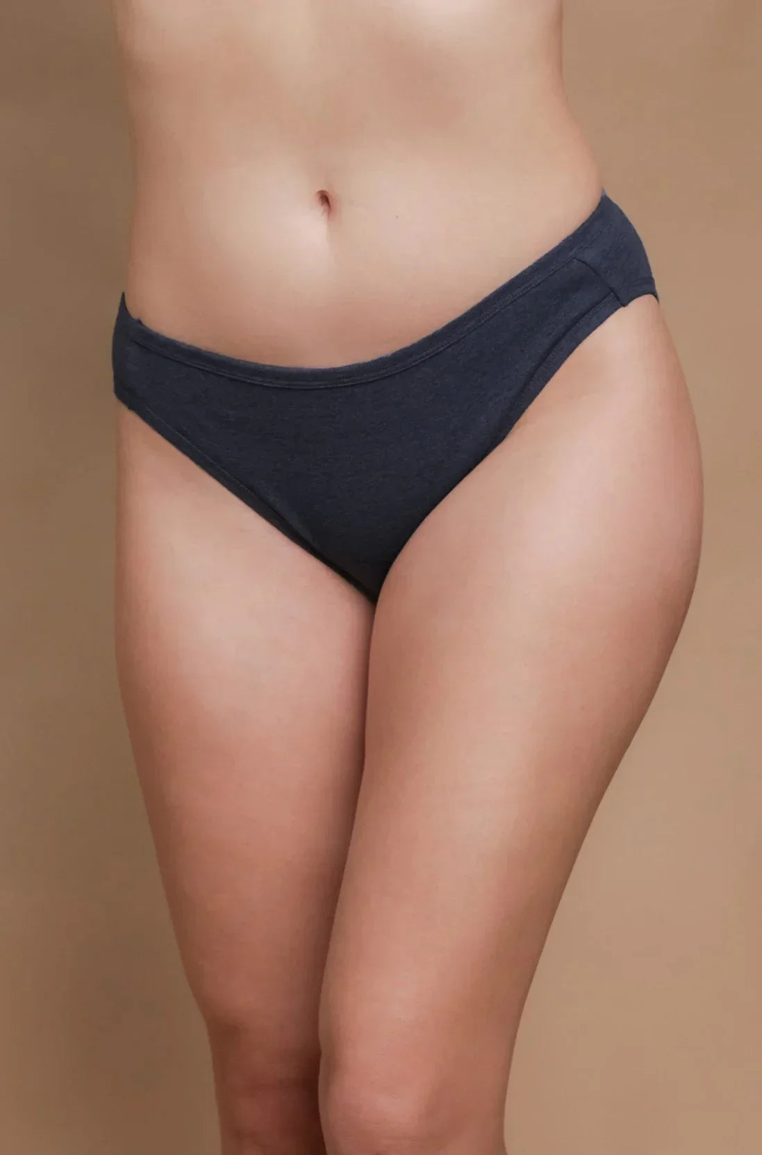 Woman wearing allergy-free cotton bikini underwear from Cottonique, dark gray on neutral background