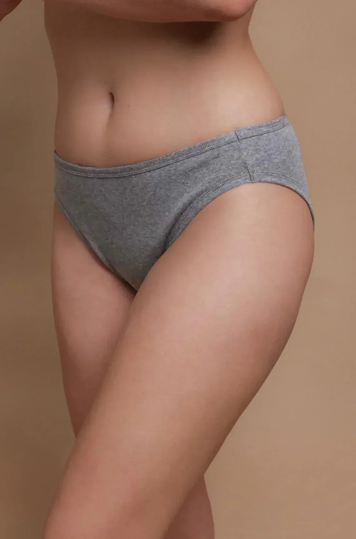 Woman wearing grey hypoallergenic cotton underwear from Cottonique on neutral background