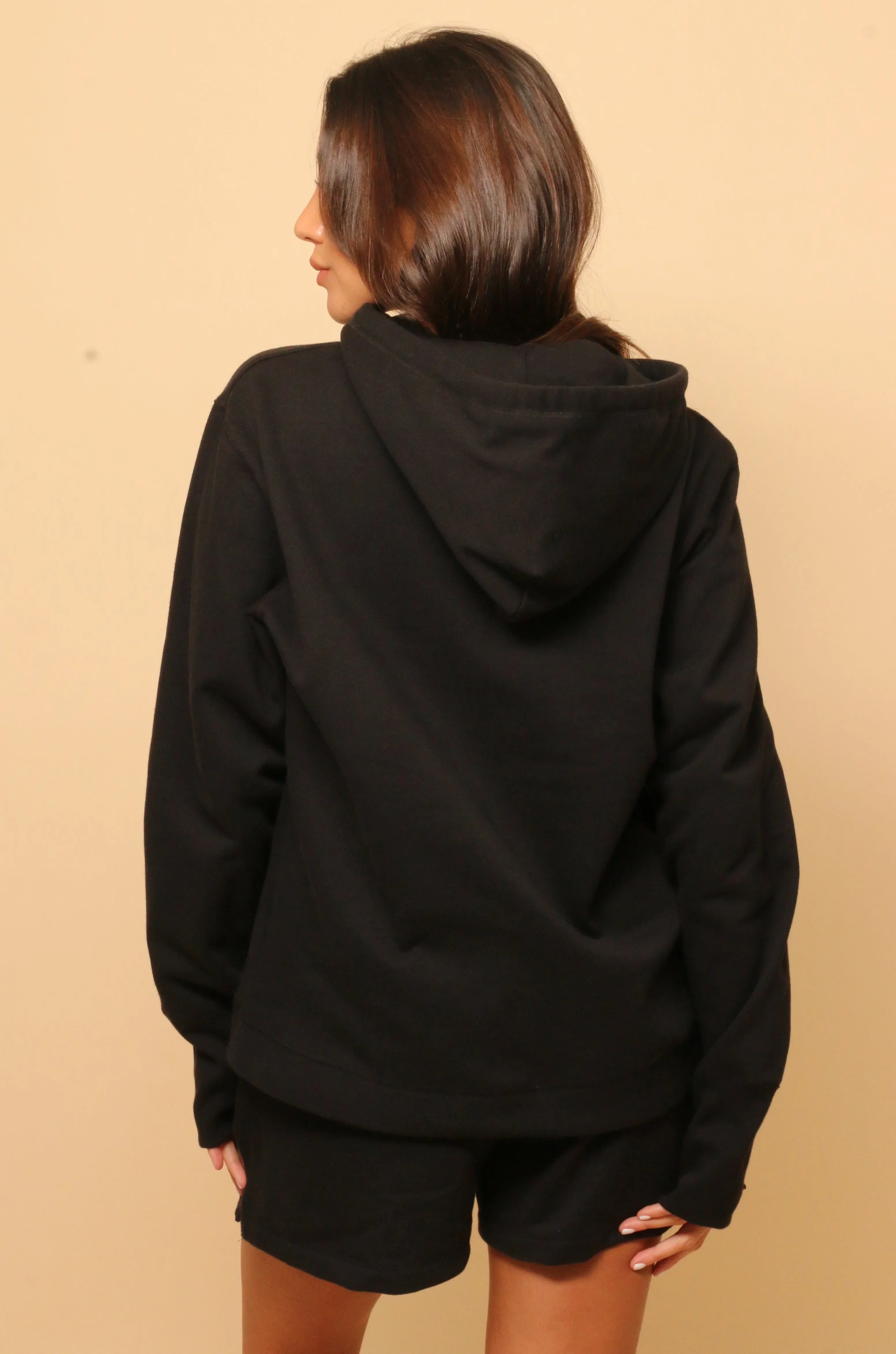 Woman wearing black hypoallergenic cotton hoodie and shorts from Cottonique, back view
