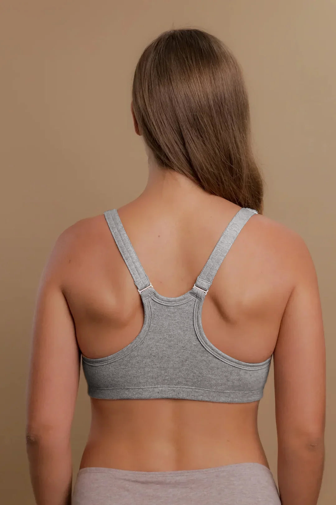 Back view of a woman wearing a grey organic cotton racerback bra for sensitive skin