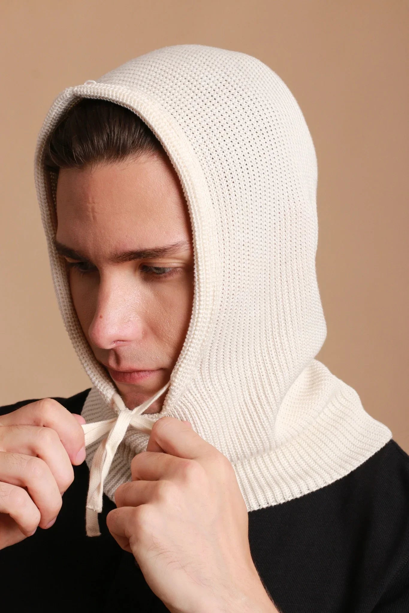 Man wearing allergy-free cotton knit hood by Cottonique, tying drawstrings close-up