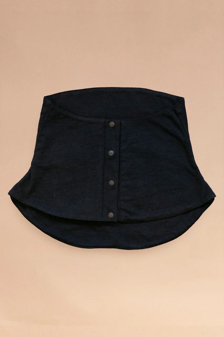 Black organic cotton allergy-free neck and chest cover-up with front snaps on beige background
