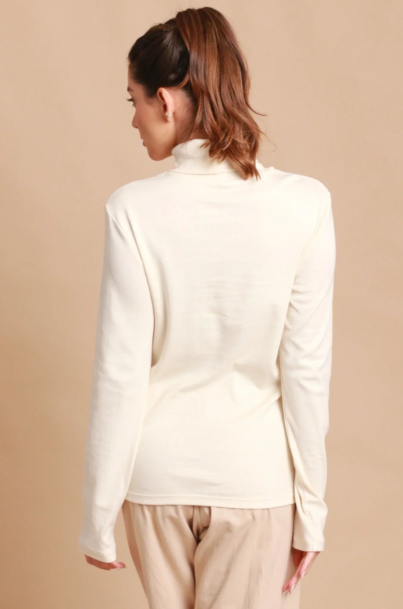 Woman wearing long sleeve organic cotton turtleneck top, back view
