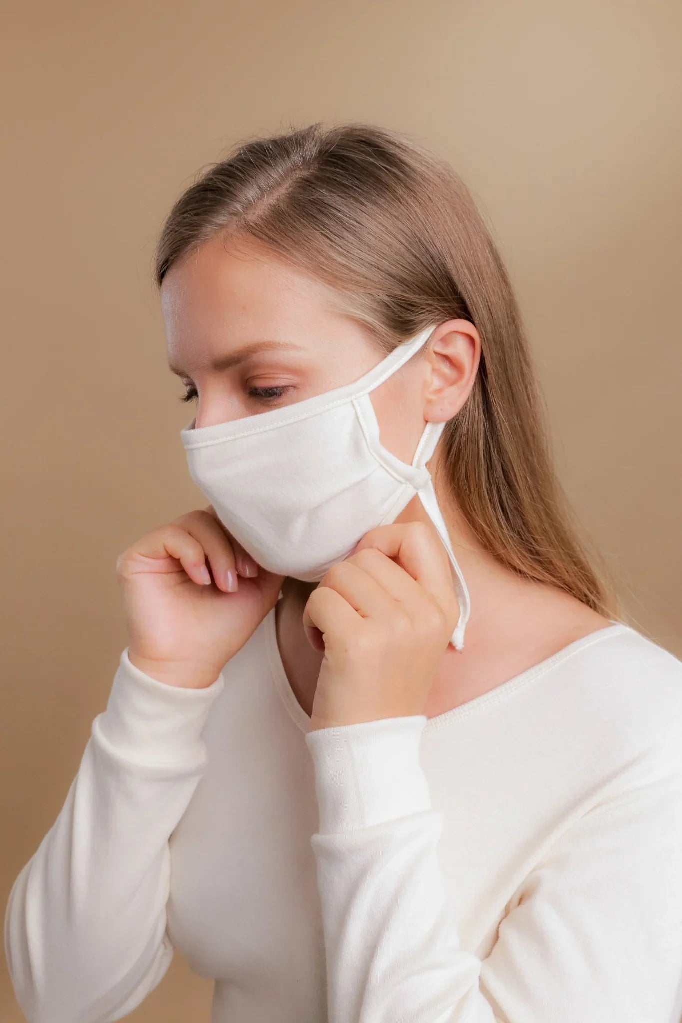 Woman wearing hypoallergenic cotton face mask and white allergy-free top by Cottonique