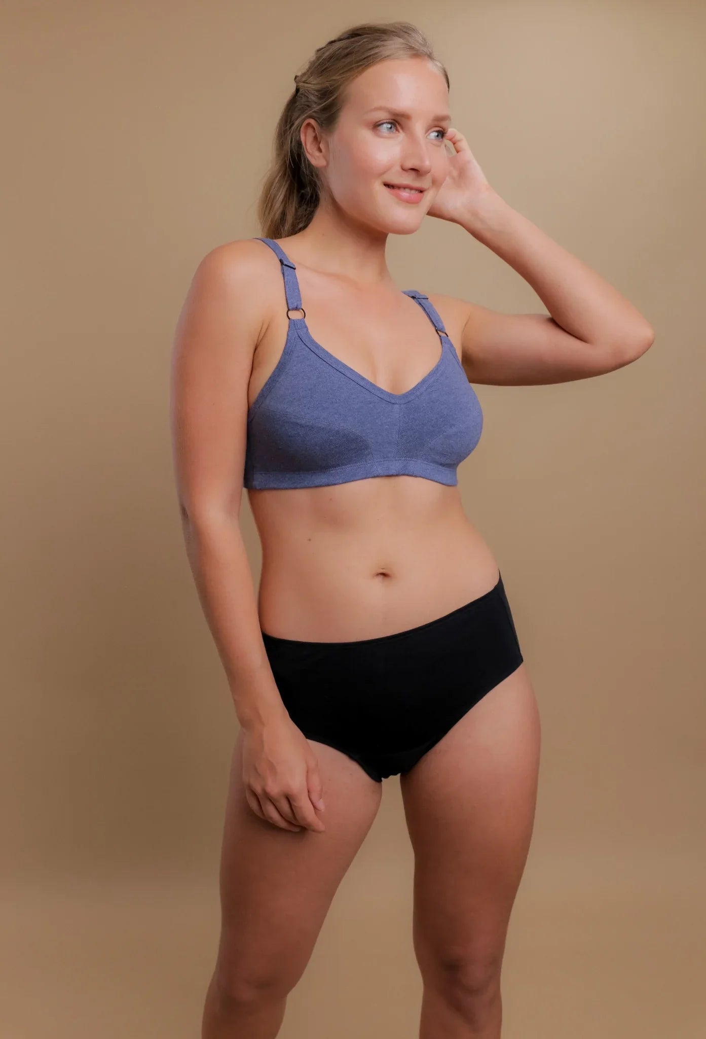 Woman modeling Cottonique hypoallergenic bra and underwear set on neutral background